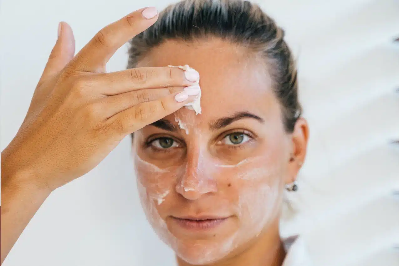 Application d'une crème à la vitamine C sur le visage pour nourrir une peau sèche