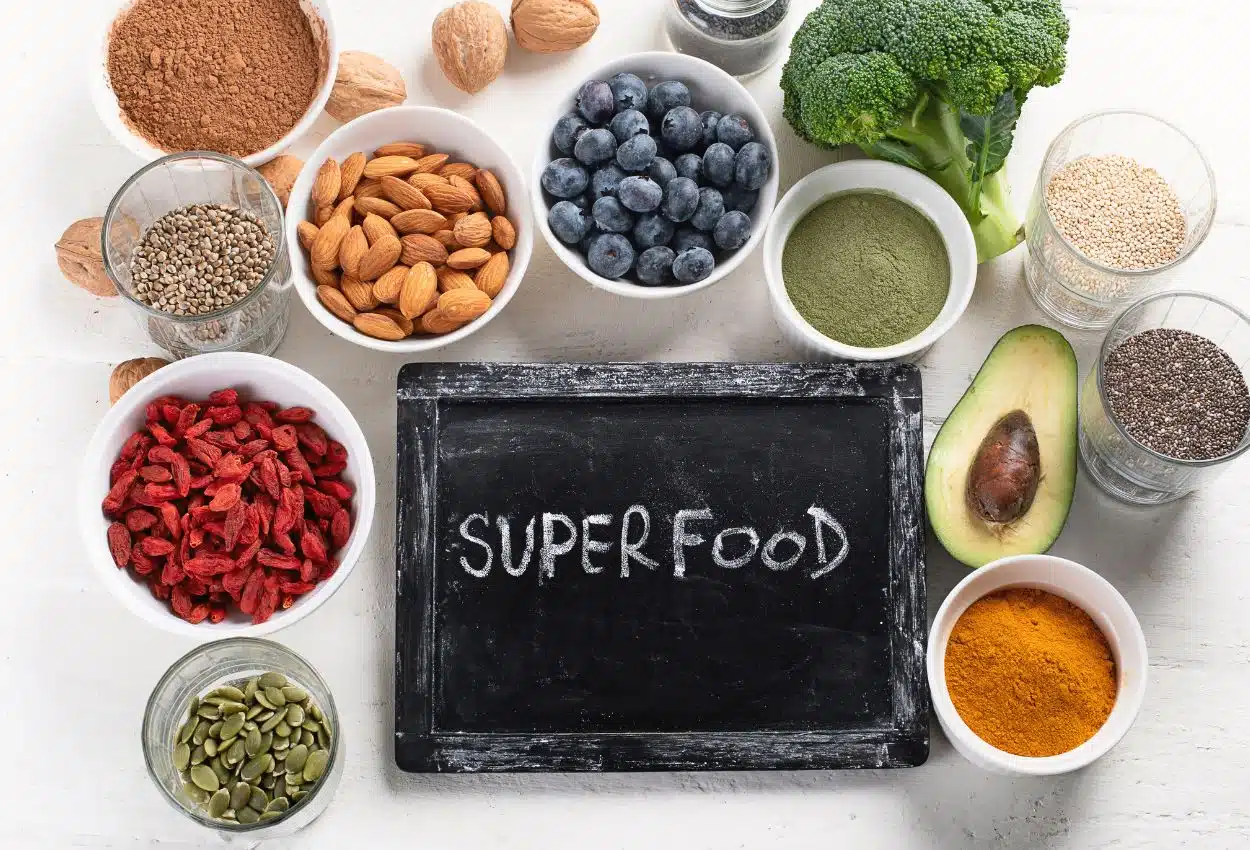 Superaliments et antioxydants : canneberge, chocolat noir, matcha Superaliments riches en antioxydants : jus de canneberge, chocolat noir, thé vert matcha disposés sur une table