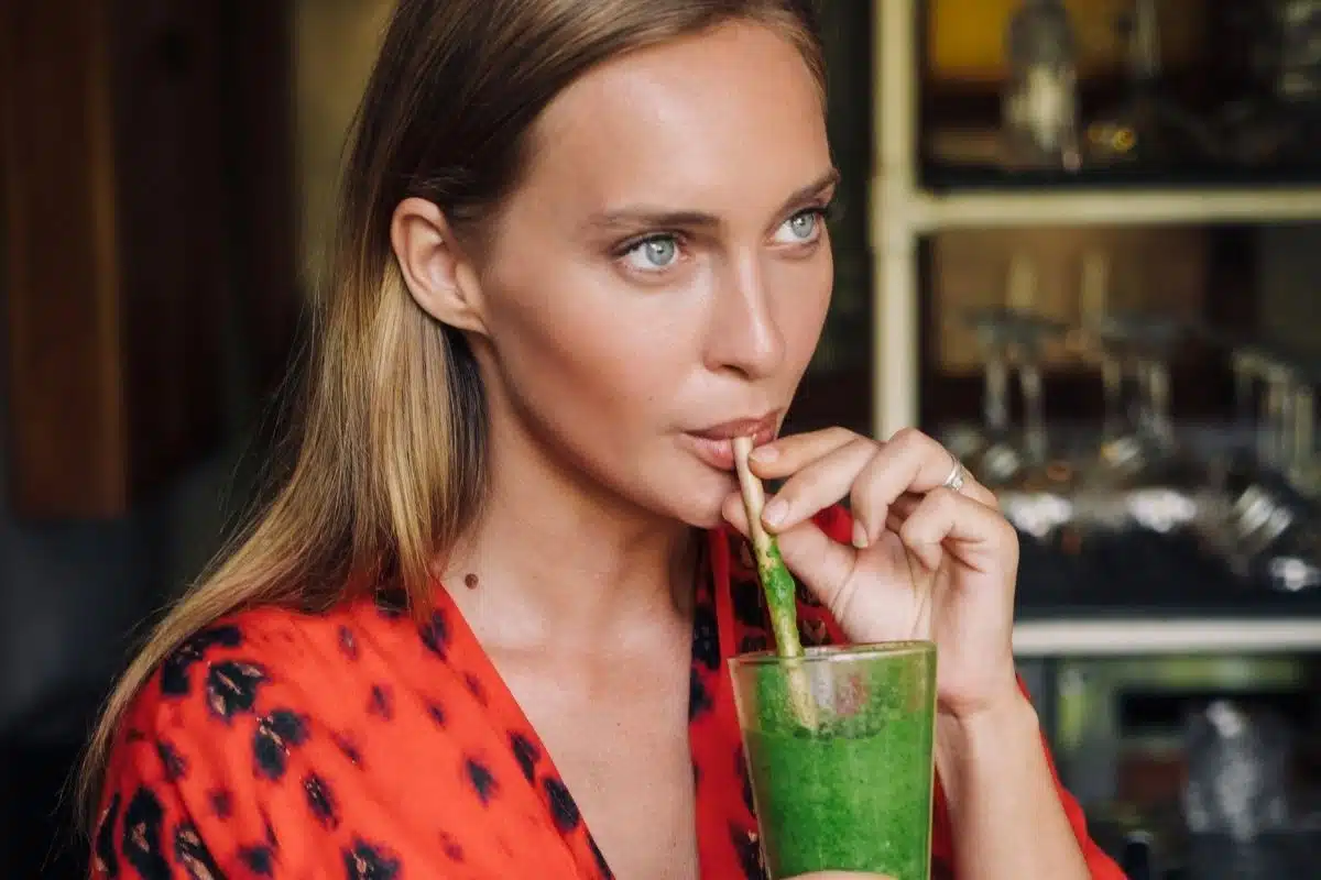 Super-aliments : femme buvant un smoothie vert à la spiruline