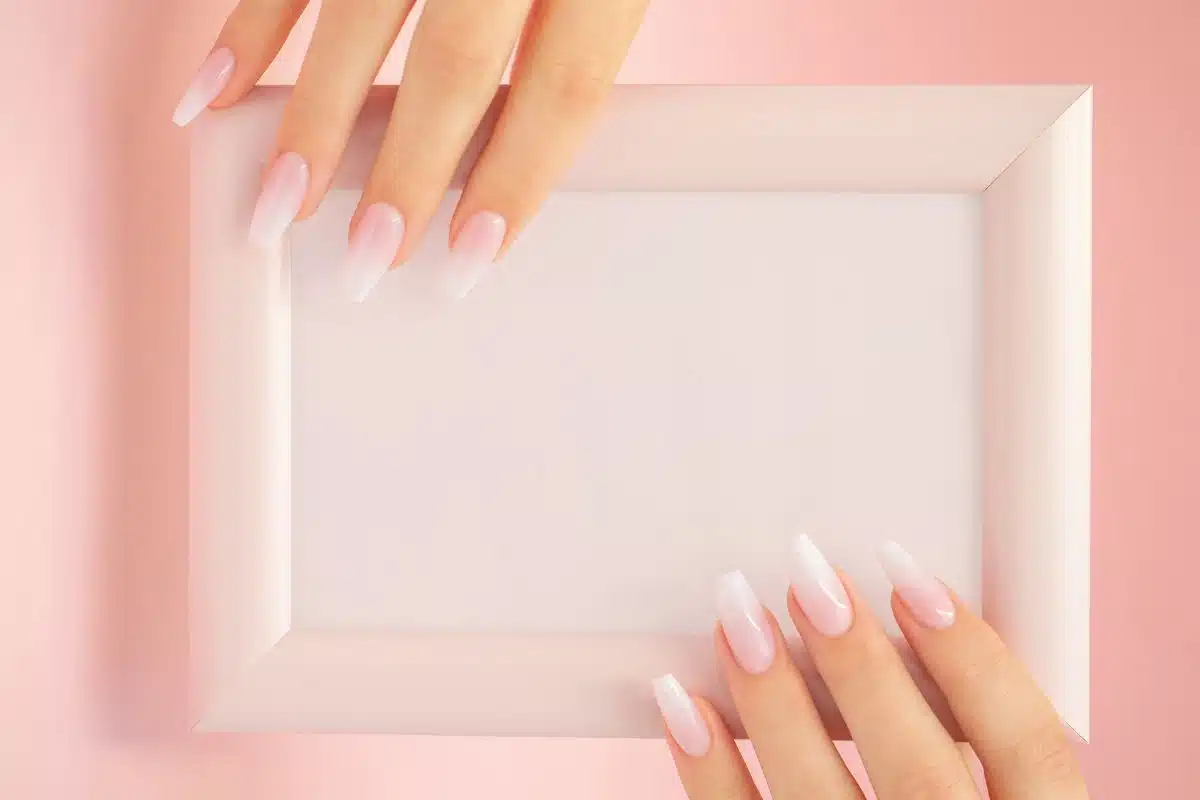 Baby boomer ongle : dégradé rose poudré et blanc sur des ongles longs en amande