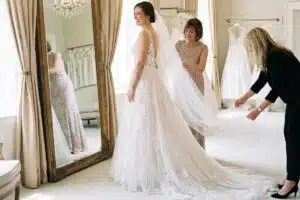 Beauté de la mariée : essayage d'une robe en dentelle devant un grand miroir doré
