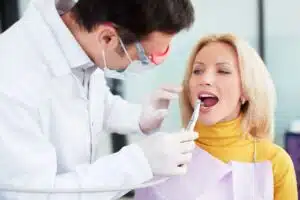 Consultation bucco-dentaire : un praticien examine la bouche d'une patiente