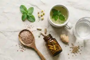 Compléments alimentaires pour le transit : gélules, graines de lin, tisane digestive et plantes sur une nappe en lin