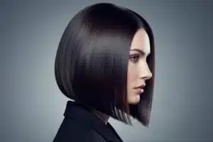 Coupe carré plongeant net vue de profil sur cheveux bruns brillants