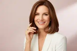 Femme souriante aux cheveux mi-longs chatains illustrant le choix d'une coupe de cheveux femme