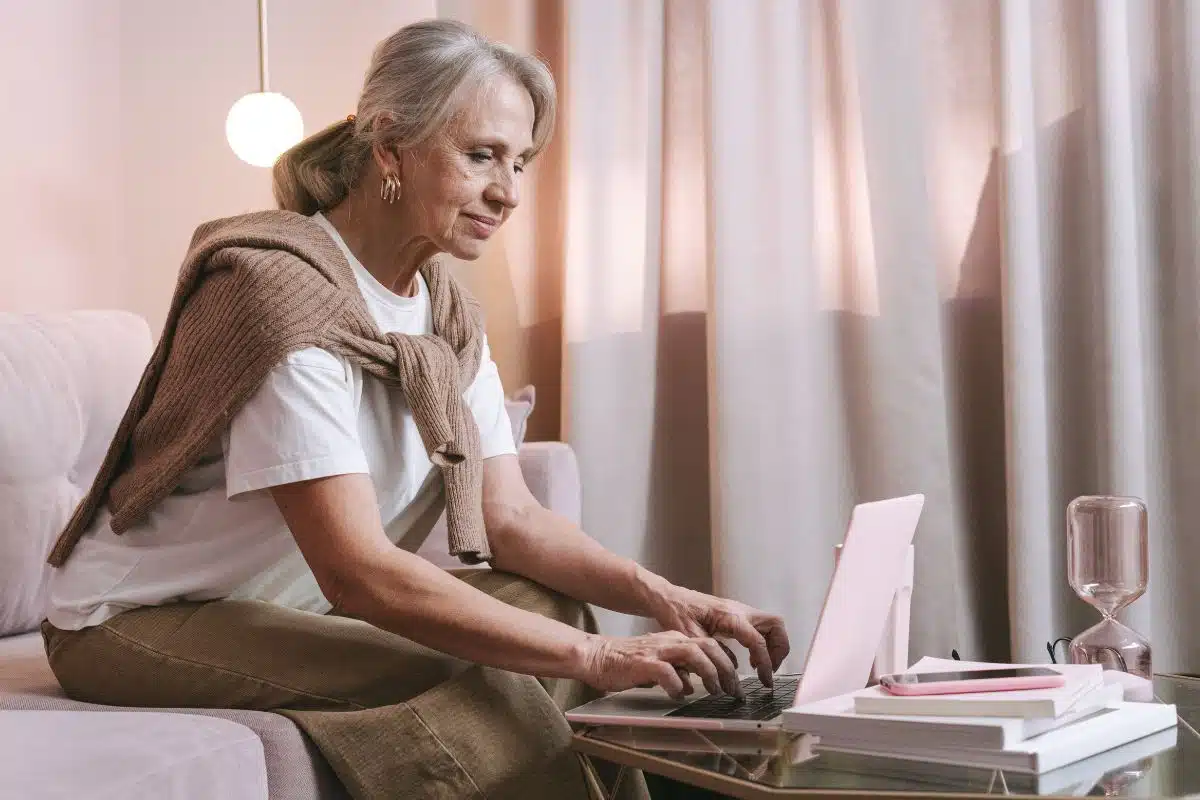 Femme senior organisant et réservant son voyage de retraite sur son ordinateur portable