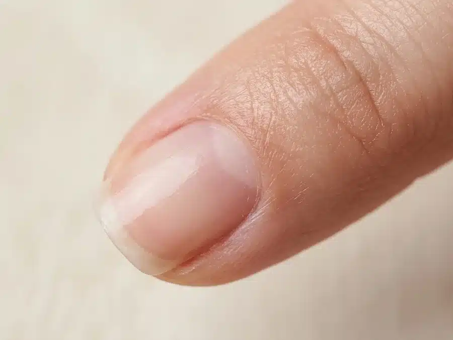 Gros plan d'un ongle naturel montrant la cuticule à la base de la tablette unguéale