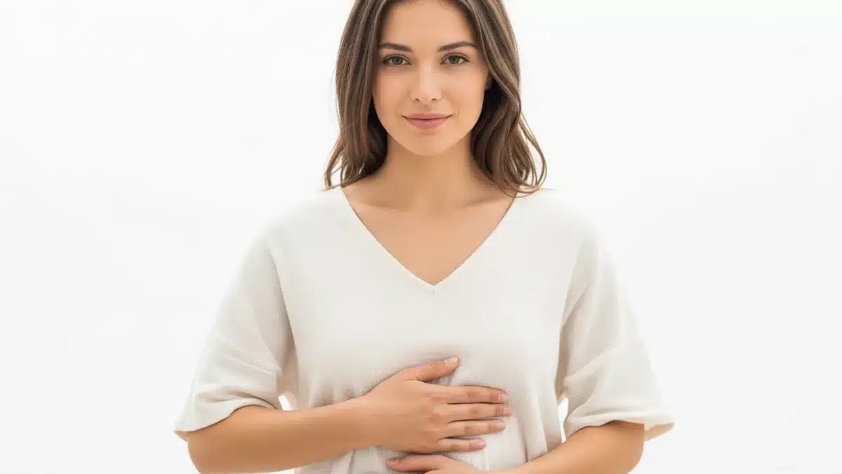 Douleurs au bas-ventre : causes et quand consulter Femme tenant son bas-ventre, douleurs pelviennes et douleurs au bas-ventre