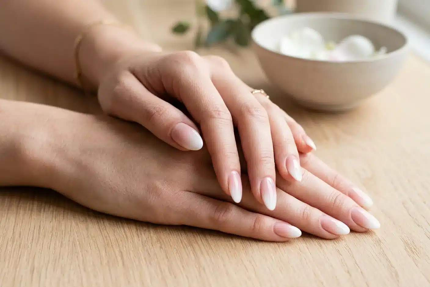 Baby boomer dégradé nude-blanc sur ongles soignés Ongles en baby boomer avec dégradé nude-blanc, gros plan sur mains