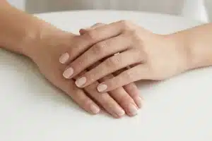 Mains aux ongles soignés avec une french manucure fine, trait blanc ultra-discret de 1 mm sur fond blanc