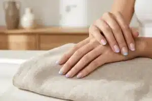 Mains soignées arborant une french manucure moderne aux extrémités pastel colorées